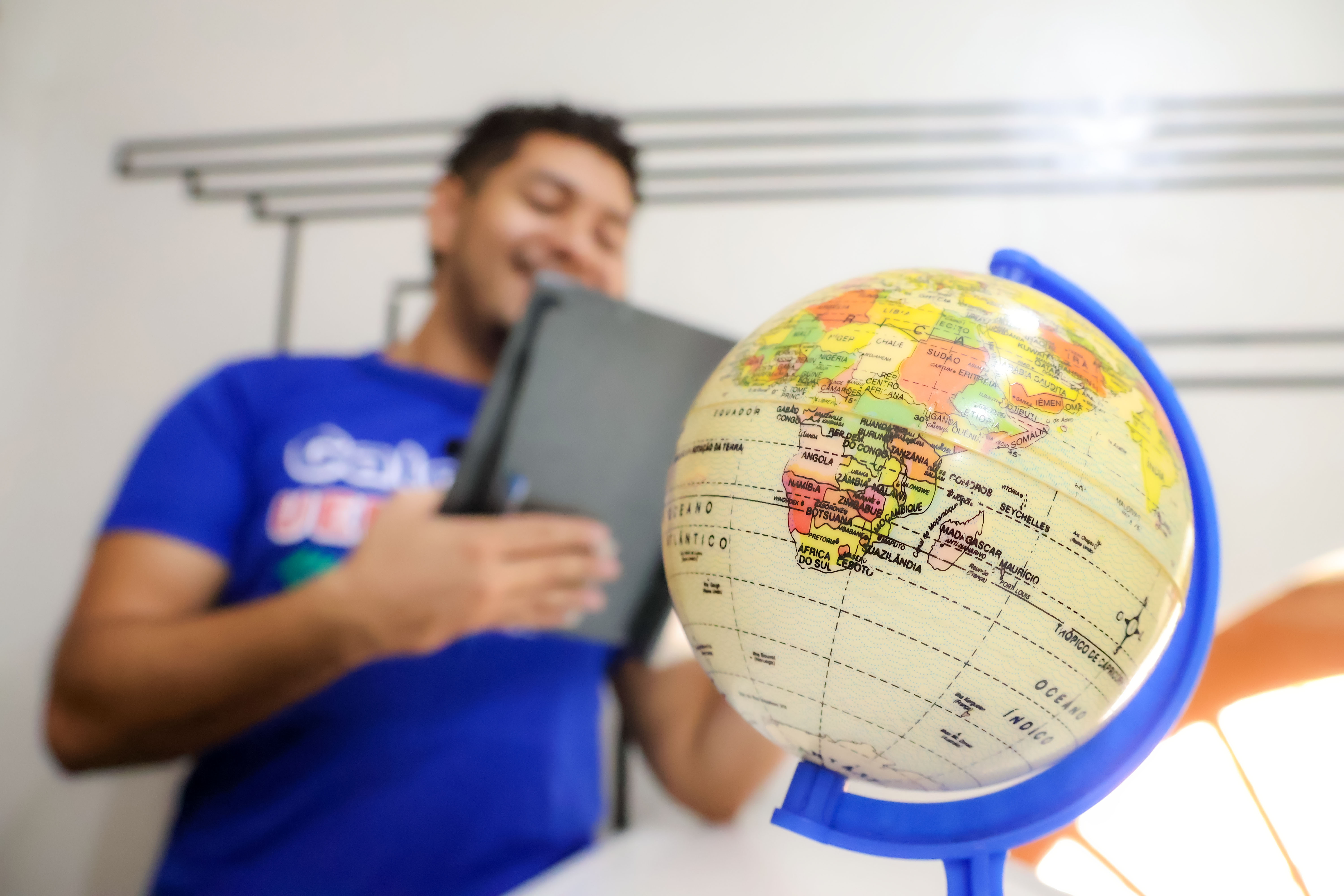 Um universitario estudante e um globo terrestre no centro da imagem