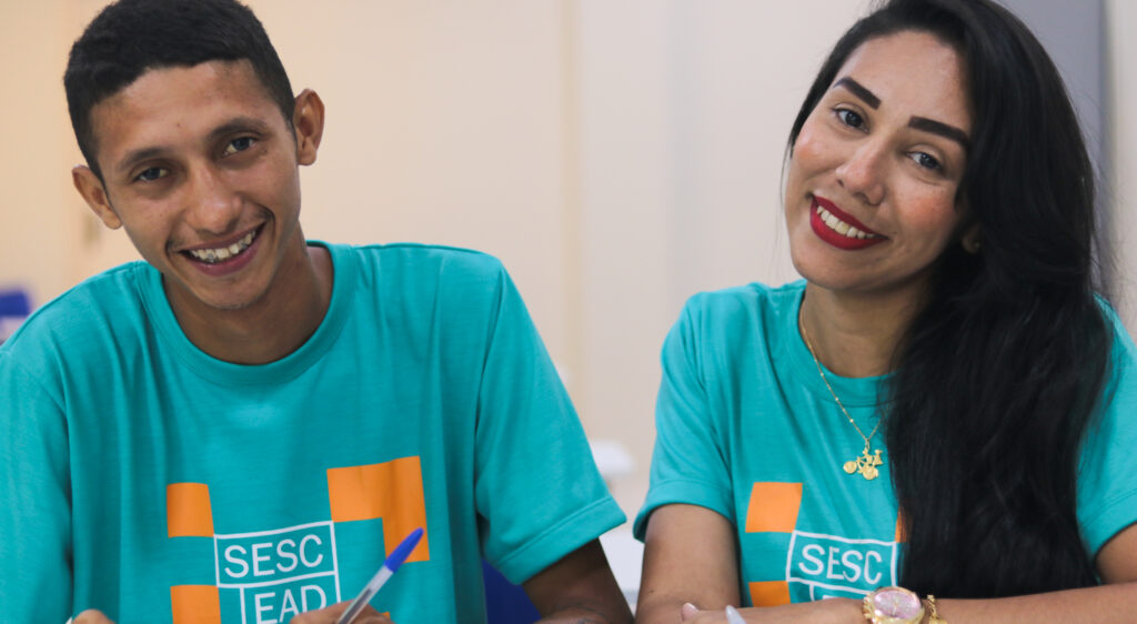 Dois estudantes do Sesc sorrindo de foto em uma sala de aula