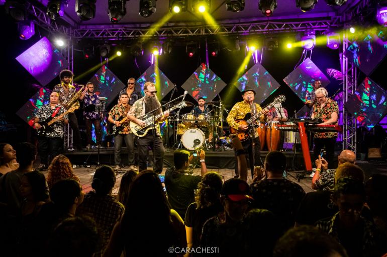 uma banda de lambada no palco se apresentando 