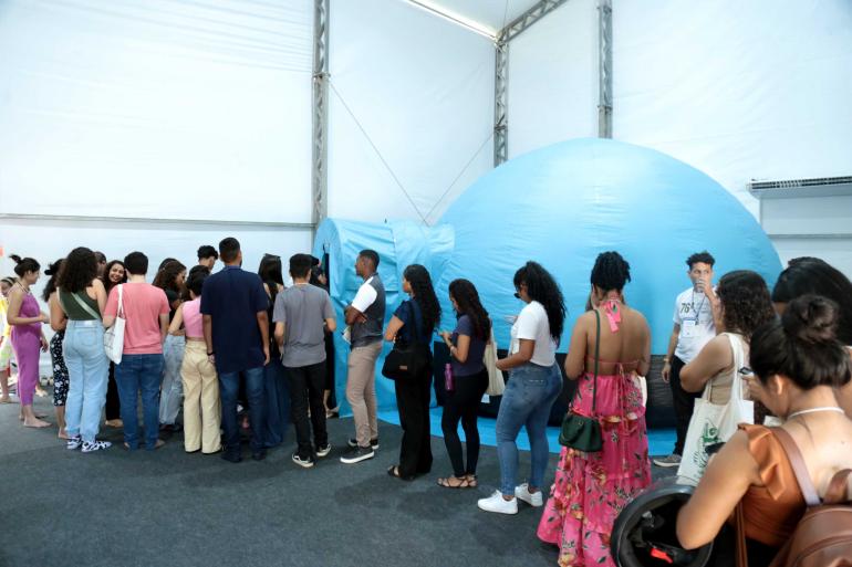 pessoas reunidas na frente do planetário móvel 