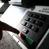 Uma pessoa apertando o dedo na urna eletrônica