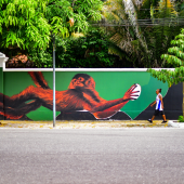 Mural pintado em cores amazônicas (Verde, amarelo, marrom) de um Mico-Leão-Dourado